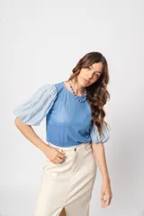 Blusa azul de cuello redondo y manga corta abullonada con puño elástico.