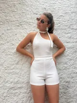 Mono corto blanco de crepe con escote halter asimétrico y choker integrado.