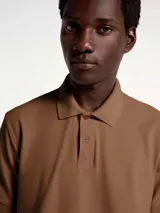 Polo marrón de manga corta confeccionada en tejido de piqué de algodón.