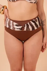 Bombacha de bikini marrón de tiro alto, con detalle de cinto estampado con rayas marrones y blancas en la cintura y aro dorado. Confeccionada con tela que contiene fibra LYCRA® XTRA LIFE™