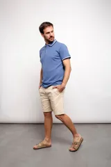 Remera polo blanca de corte regular, con cuello y mangas con detalles de doble línea en azul y negro.