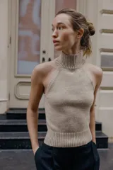 Top de punto sin mangas con cuello halter y hombros descubiertos, con terminaciones en tejido rib en cuello y ruedo.