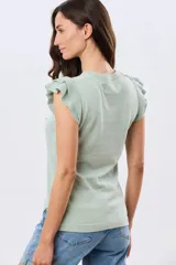 Remera tejida de algodón en color beige, de cuello redondo, sin mangas y con detalles de volados estructurados en los hombros.