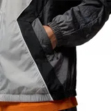 Campera rompevientos con capucha Nike Jordan, diseño color block en tonos gris claro, gris oscuro y negro. Presenta cierre frontal completo, bolsillos laterales y logo Jumpman bordado en el pecho.