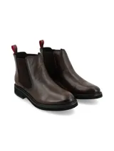 Botín tipo Chelsea de cuero color chocolate, con paneles laterales elásticos y detalle de textura tipo cocodrilo en el talón. Cuenta con suela de goma negra y tirador trasero en color rojo.