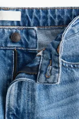 Jean barrel de tiro alto en denim de algodón rígido, con diseño curvo en las piernas y corte de cinco bolsillos.