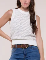 Chaleco tejido de punto calado melange, marca Elie Tahari, de color blanco. Presenta silueta semi entallada, escote a la base ligeramente elevado con terminación en punto acanalado, y sisas marcadas y ribeteadas en canalé. Confeccionado en tejido de punto con trama labrada y calados geométricos en forma de rombos, con espalda de tejido continuo y ruedo recto de largo a la cadera alta terminado en pretina ancha acanalada.