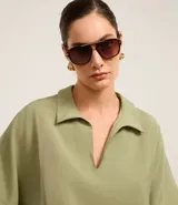 Blusa verde oliva de mangas cortas amplias, confeccionada en viscosa, con cuello y recortes verticales en los laterales.