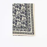 Foulard cuadrado de gran tamaño con estampado floral en color azul sobre fondo beige y borde geométrico.