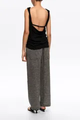 Pantalón tobillero de corte barrel color gris, confeccionado en mezcla de algodón y lino. Presenta cierre frontal con corchete oculto y cremallera, tiro medio, bolsillos delanteros en costura y bolsillos tipo plastrón en la parte trasera.