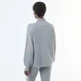 Sweater de punto acanalado en color gris, con cuello alto y mangas largas con diseño ligeramente abullonado.