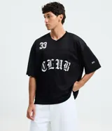 Remera negra de corte boxy y estilo deportivo, confeccionada en tejido de malla de poliéster. Presenta cuello en V, mangas corta, estampado numérico "33" en el pecho derecho y la inscripción "CLUB" en tipografía gótica en el centro.