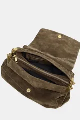 Bolso de hombro confeccionado en piel de ante, con diseño estructurado y solapa frontal con cierre imantado. Presenta pespuntes decorativos en el cuerpo y una correa combinada de cadena metálica dorada y piel.
