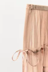 Falda corta de tiro bajo confeccionada en viscosa, con diseño de volantes superpuestos y frunces. Presenta detalle de lazadas laterales ajustables y cierre lateral con cremallera oculta.