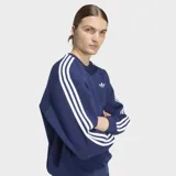 Buzo Adidas de cuello redondo con corte holgado, color azul marino. Presenta las icónicas tres rayas blancas en los hombros y mangas, y el logo del trifolio bordado en el pecho.