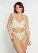 Conjunto de ropa interior compuesto por un soutien tipo top triangular sin copas y una bombacha colaless, ambos confeccionados en algodón con estampado de rayas horizontales en tonos pasteles.