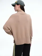 Sweater de cuello polera con hombros caídos y diseño de calce holgado. Presenta terminaciones acanaladas en puños y ruedo, confeccionado en tejido de punto suave.