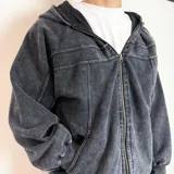 Campera con capucha y cierre frontal, confeccionada en tejido con efecto lavado desgastado. Presenta costuras decorativas horizontales en la parte superior del pecho y bolsillos laterales.