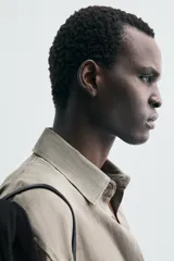 Camisa de manga larga color verde oliva, confeccionada en lino lavado con efecto ligeramente arrugado. Presenta cuello italiano y cierre frontal de botones.