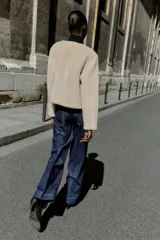 Chaqueta de cuello redondo y manga larga con tejido exterior efecto pelo e interior efecto ante. Presenta bolsillos delanteros de vivo y cierre frontal con alamares metálicos.
