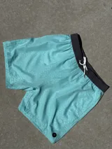 Short de baño celeste con estampado de letras y cintura elástica negra con cordón ajustable.
