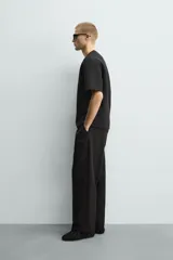 Sudadera de manga corta con corte relajado, confeccionada en tejido técnico compacto de algodón con elasticidad. Presenta cuello redondo y detalle de tacha metálica en la espalda.