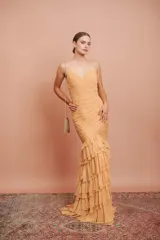 Vestido largo de fiesta color tostado, con escote en V, tirantes finos, cuerpo drapeado y falda sirena con múltiples volados en cascada.