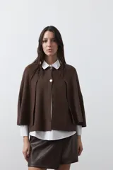 Saco tipo capa de punto color negro, con silueta fluida, corte amplio y cierre frontal con dos botones dorados.