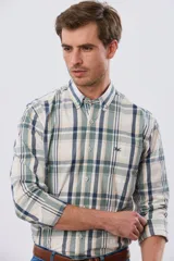 Camisa de manga larga de calce slim, con diseño a cuadros en tonos azul oscuro, verde y blanco. Presenta cuello camisero con botones y bolsillo ojal en el pecho con detalle bordado.