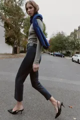 Pantalón de tiro alto con diseño de espiga, corte recto y nervio marcado en el frente. Incluye un cinturón ancho con hebilla metálica dorada y cierre lateral con cremallera oculta.
