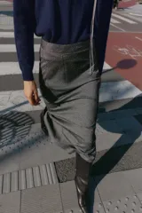 Falda midi tubo jaspeada en color gris oscuro, de tiro alto, con abertura en la espalda y cierre trasero con cremallera oculta.