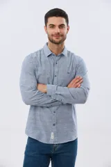 Camisa de manga larga confeccionada en mezcla de lino y algodón, con sutiles rayas celestes, cuello camisero clásico y cierre frontal de botones.
