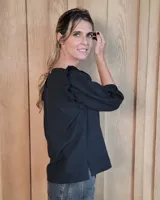 Blusa blanca de algodón tussor, con cuello redondo, mangas 3/4 abullonadas y detalle de volados en los hombros.
