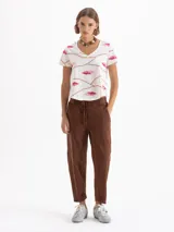 Pantalón tipo babucha de color negro, con cintura elástica y cordón de ajuste, bolsillos laterales y costuras verticales decorativas en el frente.