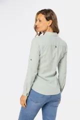 Camisa de lino color verde menta, de manga larga con botones personalizados, cuello camisero, dos bolsillos frontales en el pecho y presilla en la manga.