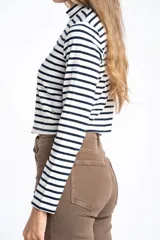 Polera de manga larga, corte ajustado al cuerpo, con cuello alto. Presenta un estampado de rayas horizontales en tonos marrón camel y azul marino.