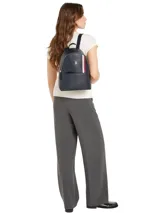 Mochila Tommy Hilfiger de diseño compacto en color azul marino. Presenta una franja vertical tricolor característica de la marca, logo TH metalizado en la parte frontal, asa superior y cierre principal con cremallera.