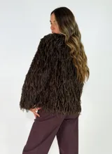 Chaqueta de textura peluda con flecos, de corte recto y manga larga, ideal para un look texturizado.