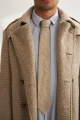 Corbata de lana color beige, forrada, de estilo skinny.