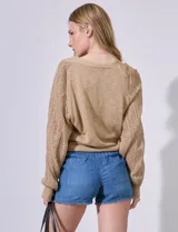 Cardigan color beige de punto con mangas largas abullonadas y detalle calado.