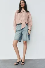 Camisa de rayas rojas y blancas, cuello redondo con lazada integrada y manga larga.