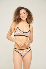Corpiño de bikini con estampado geométrico en tonos lila, verde y blanco, con breteles finos cruzados en la espalda.