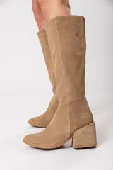 Bota bucanera de caña alta color visón, confeccionada en cuero descarne, con cierre lateral y taco cuadrado forrado.