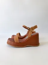 Sandalias de cuero color marrón con plataforma y pulsera al tobillo.