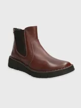 Bota corta de cuero color marrón con elástico lateral negro y suela de goma negra.