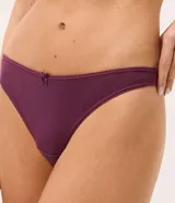 Kit de dos bombachas tipo bikini de algodón, tiro bajo, con detalle de moño pequeño en el centro de la cintura y diseño de hilo doble en la parte posterior. Incluye una prenda en color crudo y otra en bordó.