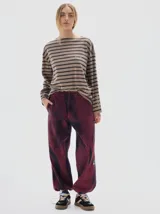 Jean parachute de denim liviano, color bordó con efecto lavado, silueta amplia y cintura y bajo ajustables.