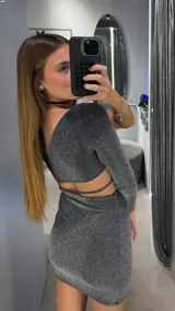 Vestido corto de lurex plateado, con diseño de un solo hombro, manga larga y abertura cut-out en la cintura.