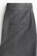 Pantalón de vestir color gris oscuro con corte bootcut. Presenta pretina prolongada con cierre oculto, bolsillos laterales al bies y bolsillos traseros ribeteados. Diseño con raya marcada adelante y atrás.