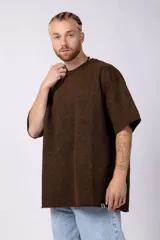 Remeron de algodón rústico con efecto de lavado gastado, corte oversize, cuello redondo y mangas cortas con terminaciones al corte.